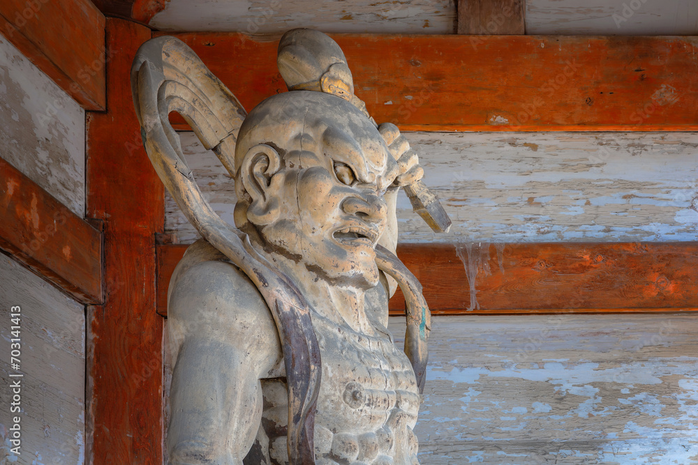Nio, wrathful and muscular guardians of the Buddha stand guard at the  of Ninnaji temple's gatein Kyoto, Japan