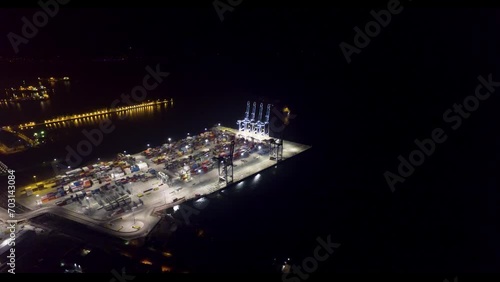 night drone view of giant cranes in the port