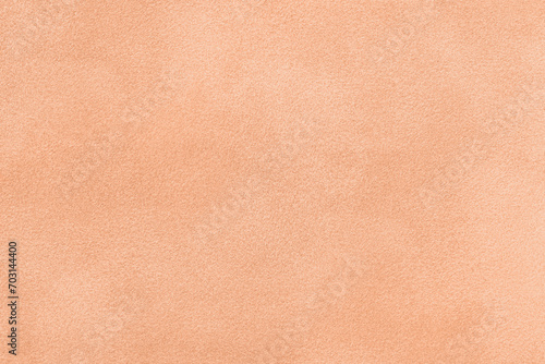Color of year 2024 peach fuzz. Light coral matte background of suede fabric. Velvet texture of textile, photo