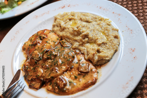 Cuisine specialty in Swiss Ticino and Grisons - Polenta Rosso with meat pieces and boletus mushroom. Polenta rosso is a red corn species growing in the south of Switzerland