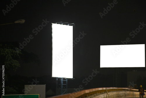 Two blank white billboards for advertising mockup on tower near higway at night photo