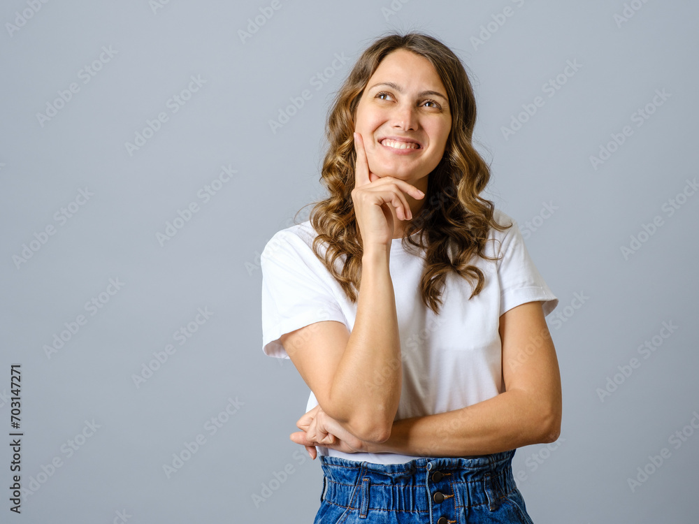 Portrait of a casual pretty young smiling woman thinking about something isolated Portrait of a casual pretty young smiling woman thinking about something isolated