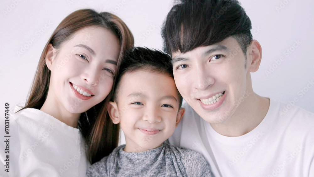 Happy family and child hugging and looking at camera Happy family and child hugging and looking at camera