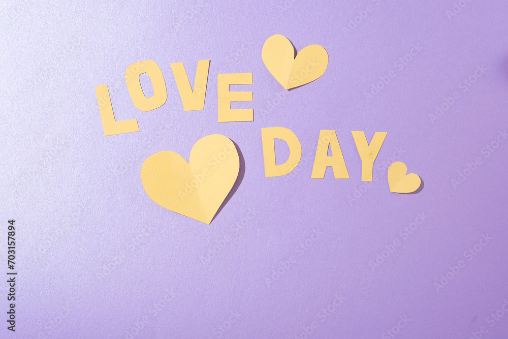 LOVE DAY lettering and paper hearts on a soft pastel background. Ideal for anniversary ads. Top view, flat lay, with ample copy space. Create a romantic ambiance. LOVE DAY lettering and paper hearts on a soft pastel background. Ideal for anniversary ads. Top view, flat lay, with ample copy space. Create a romantic ambiance.