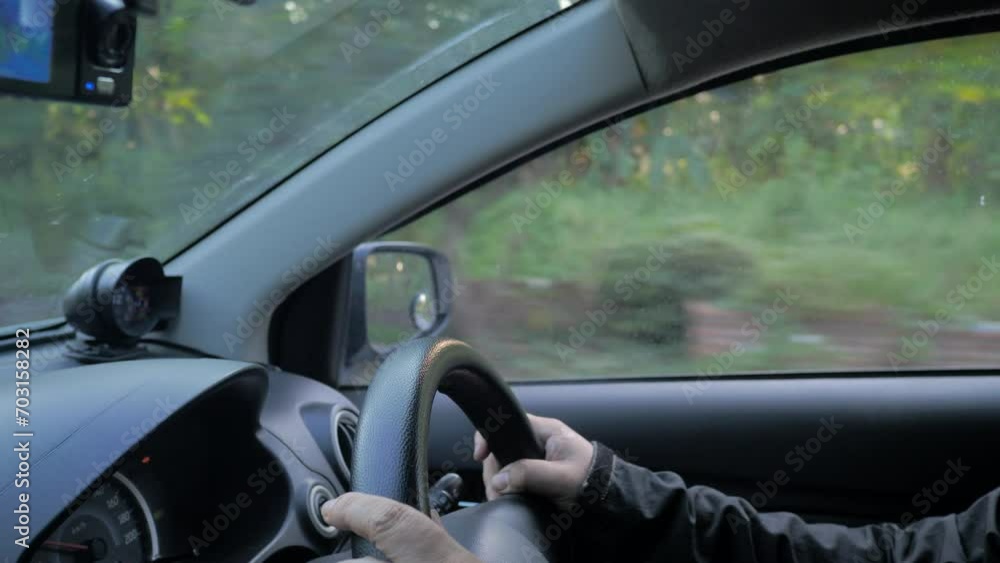 The man driving a car on the rural road. Close-up shot. The man driving a car on the rural road. Close-up shot.