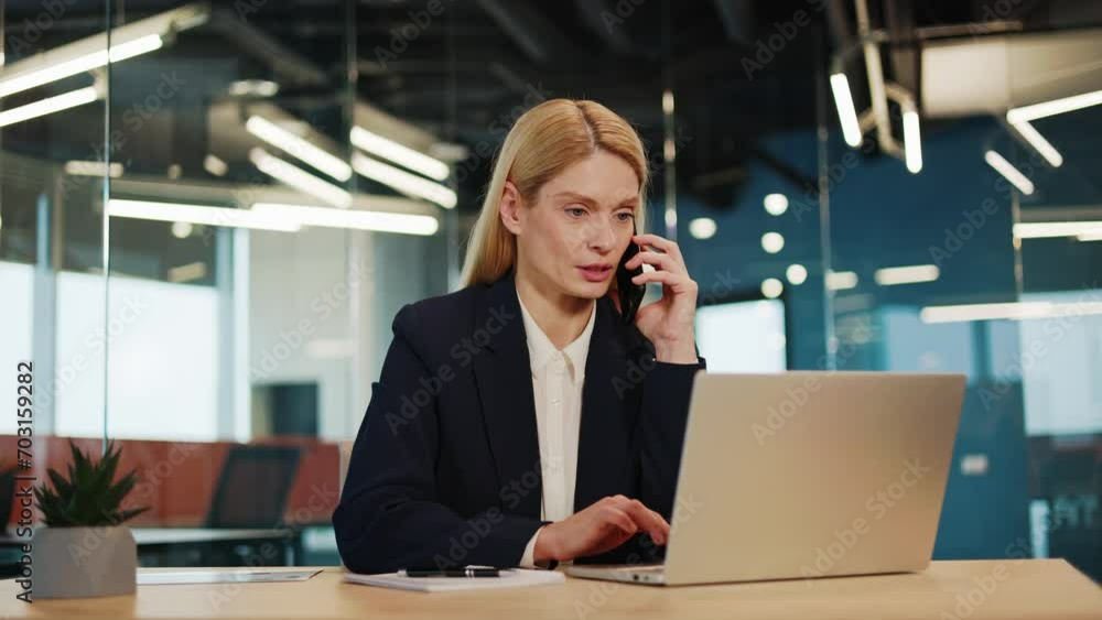 Female office worker, manager consulting client over the phone while simultaneously reviewing information on her laptop screen. Professional teleworker, broker, saleswoman offering goods and services. Female office worker, manager consulting client over the phone while simultaneously reviewing information on her laptop screen. Professional teleworker, broker, saleswoman offering goods and services.