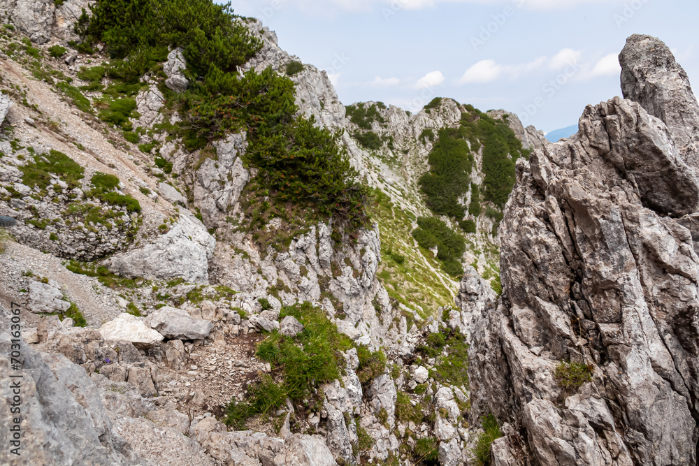 Scenic hiking trail to mountain peak Cima del Cacciatore in remote Julian Alps, Friuli-Venezia Giulia, Italy. Trailhead from Monte Santo di Lussari, Camporosso. Wanderlust in untamed Italian Alps
