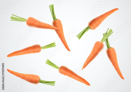 Fresh ripe carrots falling on white background