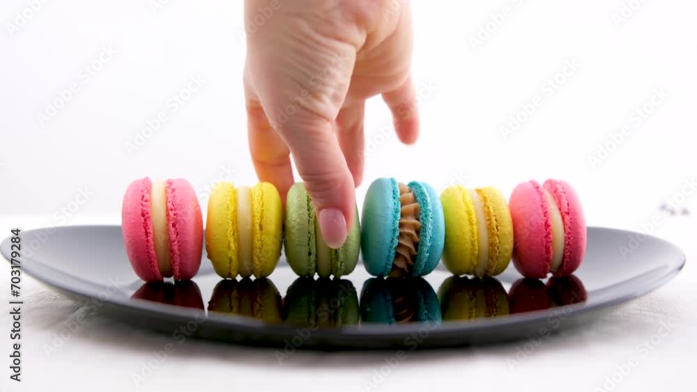 beautiful multi-colored pasta blue yellow pink green on a black plate white background whirl ride ride cook delicious french dessert lunch different toppings female hands cook tasty beautiful multi-colored pasta blue yellow pink green on a black plate white background whirl ride ride cook delicious french dessert lunch different toppings female hands cook tasty