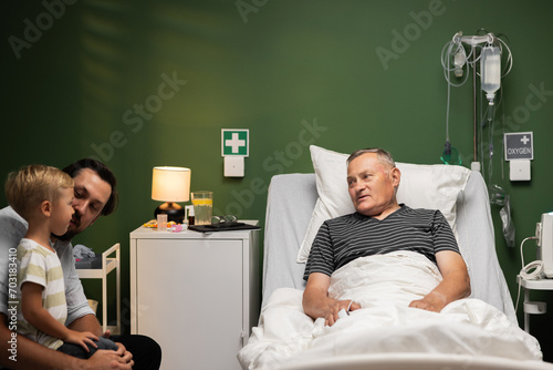 Vászonkép The older man, amidst his hospital stay, finds solace in the visit from his son and grandson, their love a source of strength