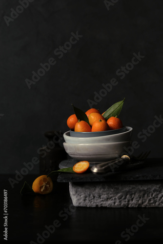 Fototapeta Naklejka Na Ścianę i Meble -  Stillleben mit Kumquats vor dunklem Hintergrund