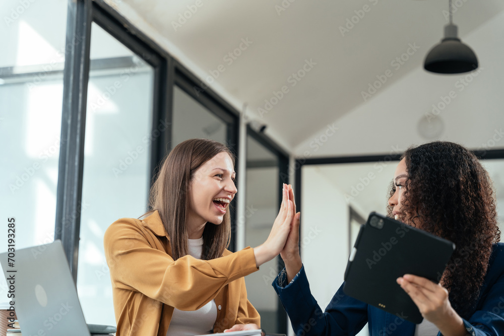 Fototapeta premium Business woman are excited business success with inspiration from their excellent financial results that are happy working in a modern office on a Tablet and computer.