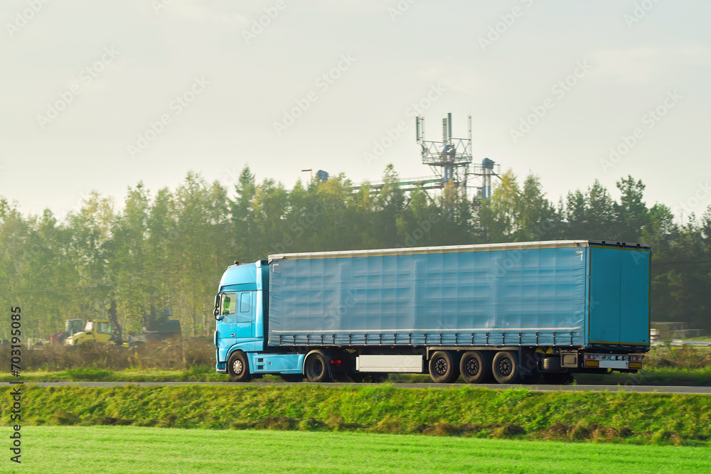 Side view of truck with semitrailer shipping goods on the highway. Sustainable future global supply chain. Export and import in the EU economic zone. Logistics and shipping concept. Side view of truck with semitrailer shipping goods on the highway. Sustainable future global supply chain. Export and import in the EU economic zone. Logistics and shipping concept.