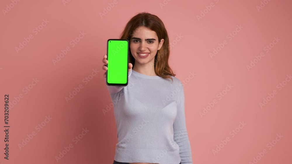 Woman showing cellphone with green screen in studio Woman showing cellphone with green screen in studio