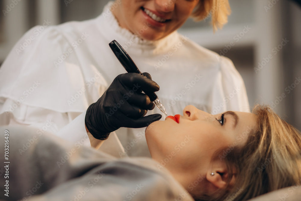 Naklejka premium Permanent Makeup For Eyebrows. Closeup Of Beautiful Woman With Thick Brows In Beauty Salon. Beautician Doing Eyebrow Tattooing For Female Face. Beauty Procedure. High Resolution