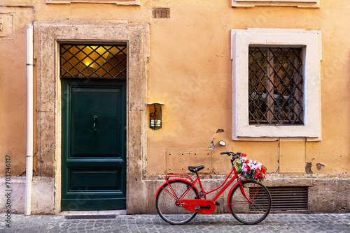 Image of a red bicycle on an old narrow cobblestone street in Rome, Italy.
