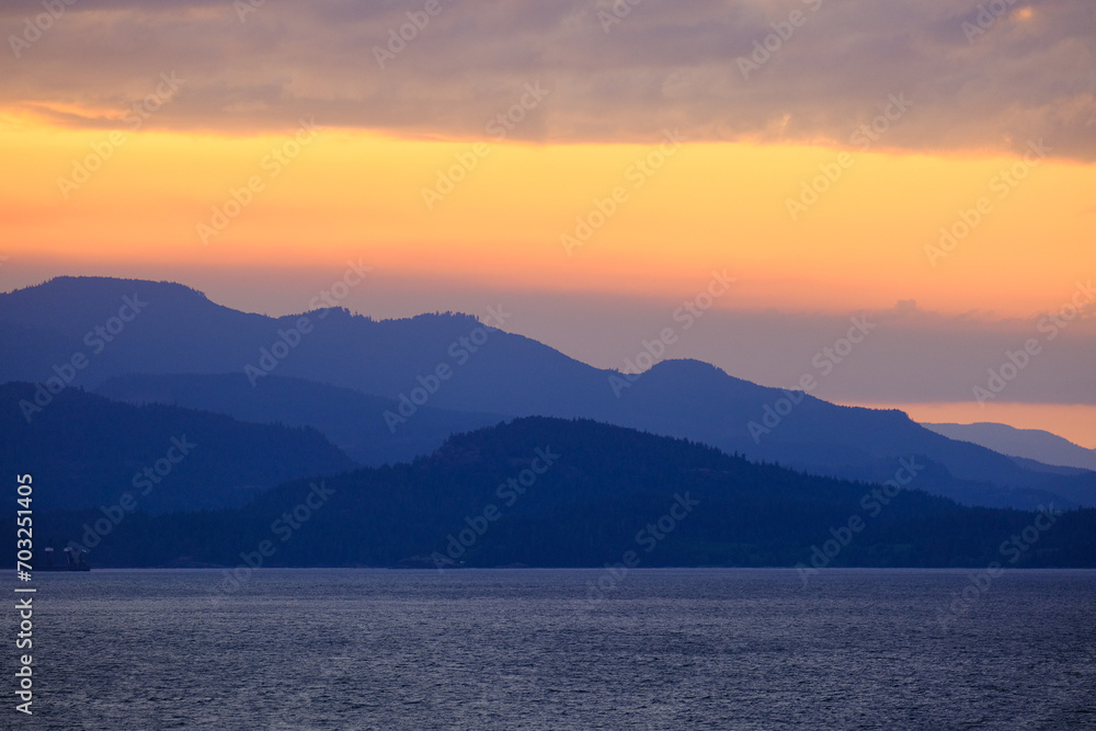 Panoramic sunrise or sunset landscape nature coastal scenery with beautiful fire sky and dramatic cloudscapes in Alaska Inside Passage glacier mountain range view