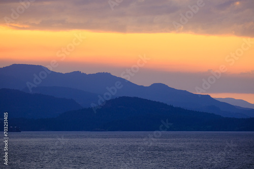 Panoramic sunrise or sunset landscape nature coastal scenery with beautiful fire sky and dramatic cloudscapes in Alaska Inside Passage glacier mountain range view © Tamme