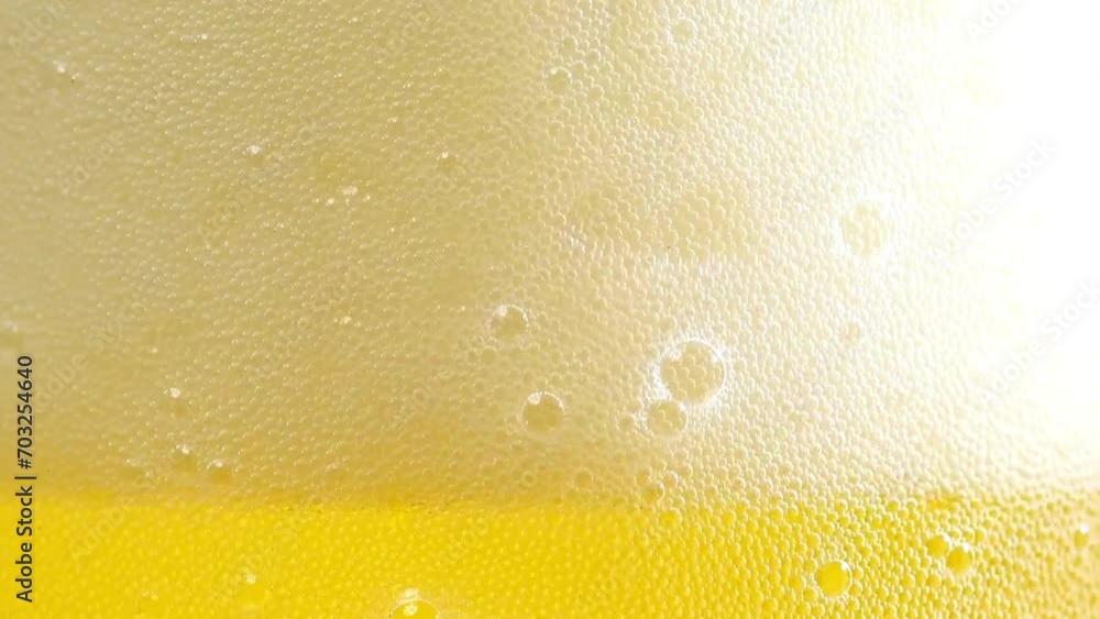 Low angle of foamy beer filling glass cup in slow motion on black background. Low angle of foamy beer filling glass cup in slow motion on black background.