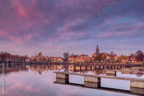 View on the historic harbor and center of Blokzijl, a typical and historic town in the Weerribben Wieden,  with monumental buildings, golden age trade center, horizontal shot during colorful sunset © IJtje