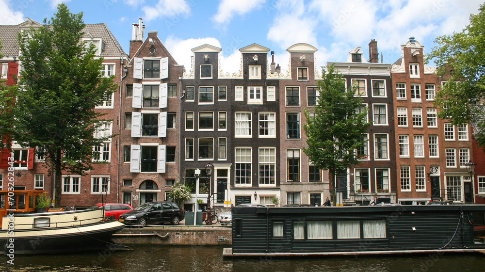 façades de maisons flamandes typiques en briques le long d'un canal à Amsterdam aux Pays Bas