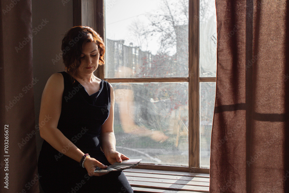 Fototapeta premium a woman makes a layout on tarot cards, tells fortunes, plays solitaire, predicts the future