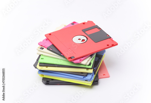 Stack of colored floppy disks on white background