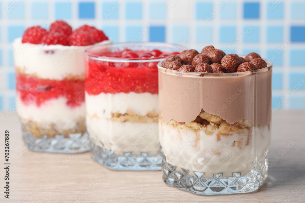 Homemade layered Desserts in a glass cups with yogurt and chocolate balls on table Homemade layered Desserts in a glass cups with yogurt and chocolate balls on table
