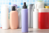 Spray  and other cosmetic product bottles on a tile background