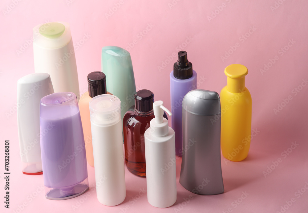 Different shampoo and other cosmetic product bottles on pink background Different shampoo and other cosmetic product bottles on pink background