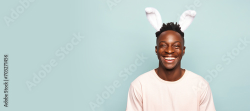 Adult African American mature man with cute bunny rabbit ears on studio pink orange background. Empty space place faor text, copy paste, horizontal banner