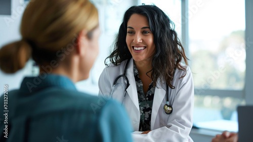Smiling middle-aged female doctor listening to female patient talk about her health