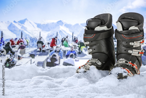 Ski boots on snow and winter landscape of mountains.  photo