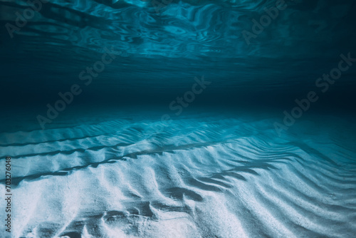 Tropical transparent blue ocean with sandy bottom. Panoramic underwater view with artificial light