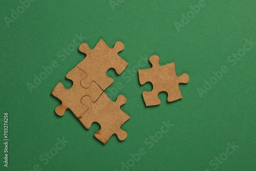 Wooden pieces jigsaw puzzle on green background
