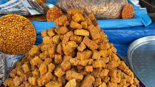 Rotating shot of delicious traditional fried sweets on display at a roadside stall on a cold winter day in Kolkata, India. photo