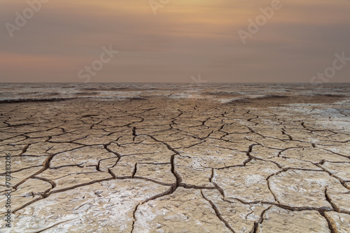 Cracked mudflats of the Waddensea by Westhoek, friesland, the Netherlands, tidal landscape like a desert in warm months of the year, sunset 