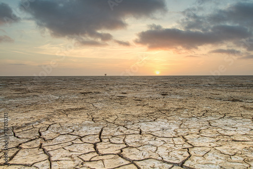 Cracked mudflats of the Waddensea by Westhoek, friesland, the Netherlands, tidal landscape like a desert in warm months of the year, sunset    photo
