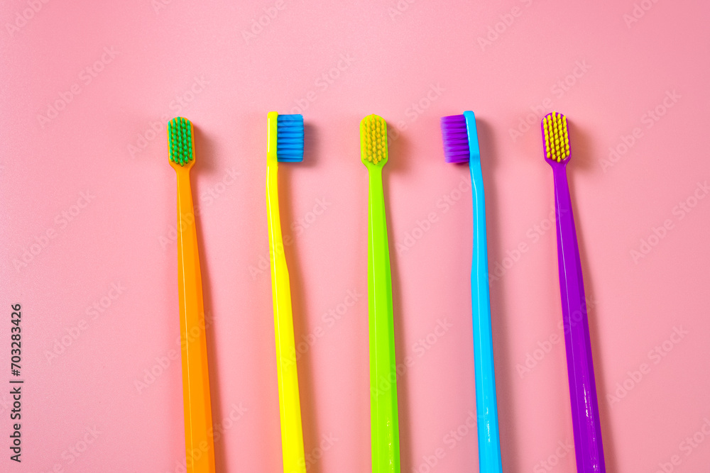 A bright composition of toothbrushes of different colors. Bright background with toothbrushes, free space for text or logo. A bright composition of toothbrushes of different colors. Bright background with toothbrushes, free space for text or logo.