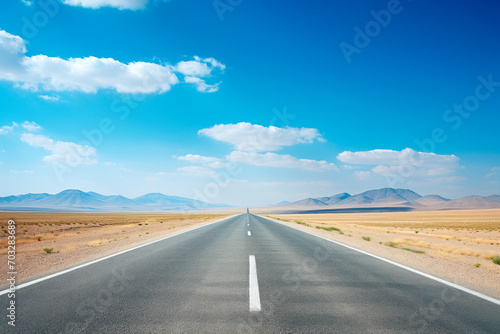 Empty asphalt highway along desert with mountains on horizon.
