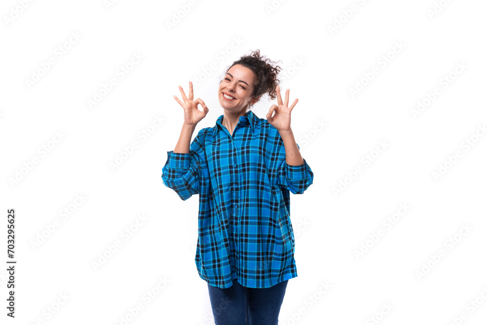 young smiling energetic curly european woman dressed casually in a blue plaid shirt on a white background young smiling energetic curly european woman dressed casually in a blue plaid shirt on a white background