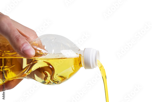Sunflower oil pouring from bottle in a glass bowl. Isolated on white background
