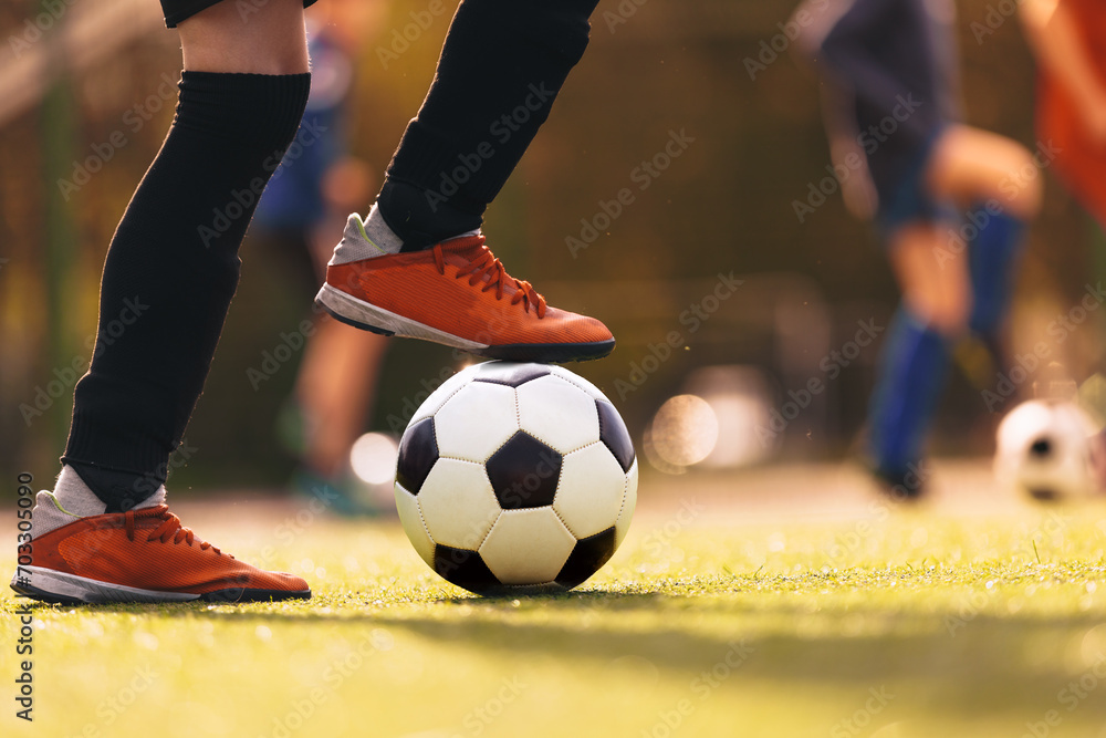 Teenagers on sports training. The player kicking a classic soccer ball. Group of youth soccer players playing with balls on a practice session. Football camp for school kids - obrazy, fototapety, plakaty 
