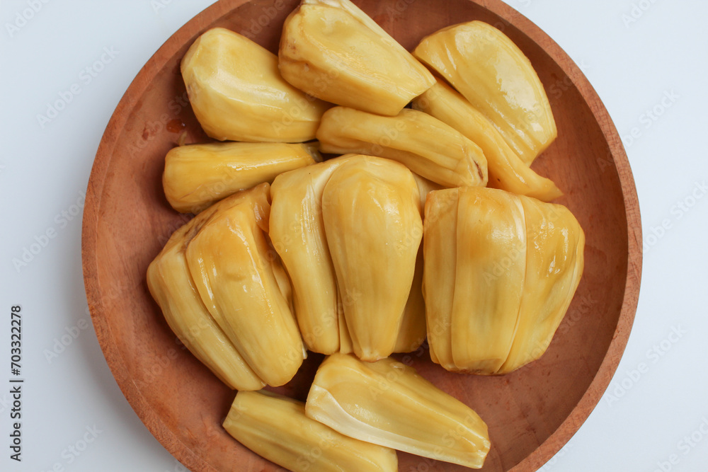 Yellow Jackfruit flesh from Artocarpus heterophyllus, on wooden plate, isolated on white background, flat lay or top view Yellow Jackfruit flesh from Artocarpus heterophyllus, on wooden plate, isolated on white background, flat lay or top view