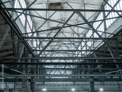 Interior of large industrial hall with metal roof trusses
