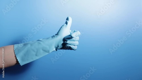 cleaning service, good cleanup, a hand in a glove shows a thumbs up on a blue background photo