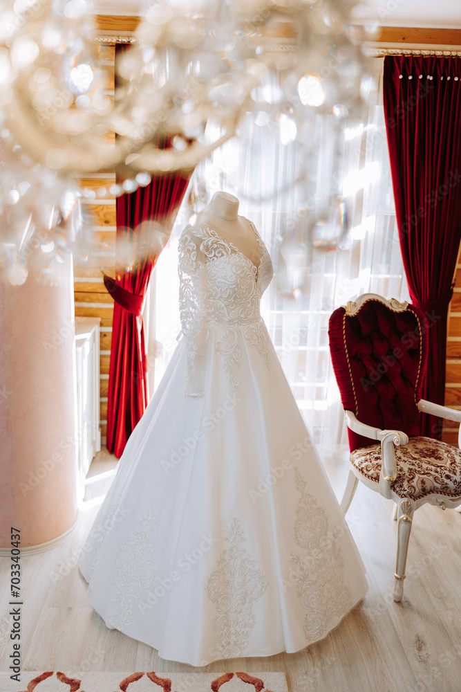 Bedroom interior with wedding dress prepared for the ceremony. A beautiful lush wedding dress on a mannequin in a hotel room. Bedroom interior with wedding dress prepared for the ceremony. A beautiful lush wedding dress on a mannequin in a hotel room.