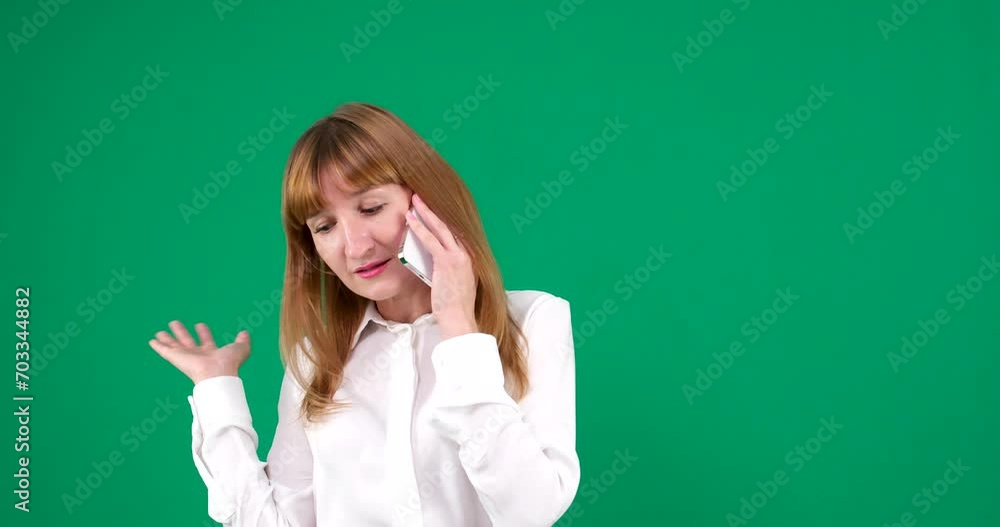 On a green chromakey background, a woman solves problems, screams, swears, talks on the phone, waves her hand, office worker, white blouse, red blond hair. On a green chromakey background, a woman solves problems, screams, swears, talks on the phone, waves her hand, office worker, white blouse, red blond hair.