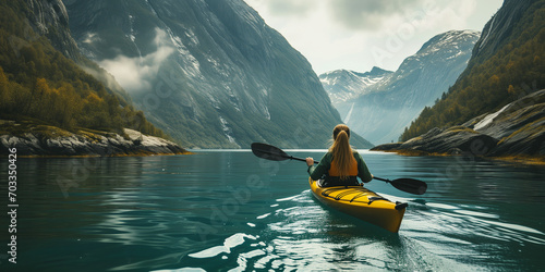 Woman kayaking in a lake with mountains in the background, norwegian nature, Landscape Image with Copy Space © Ammar Anwar 