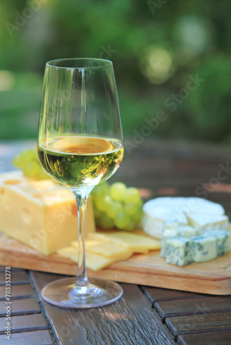 Various sorts of cheese, grapes and white wine